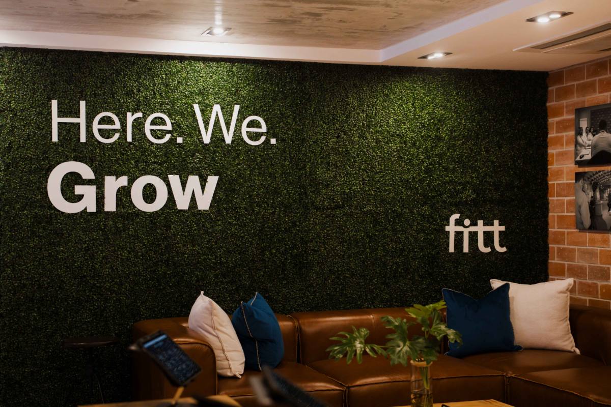 The Fitt Idea Lounge lounge area with the &lsquo;Here. We. Grow.&rsquo; living wall and leather seating.
